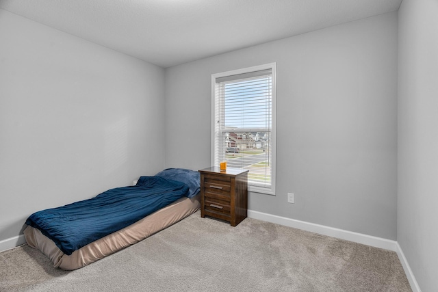 carpeted bedroom featuring baseboards