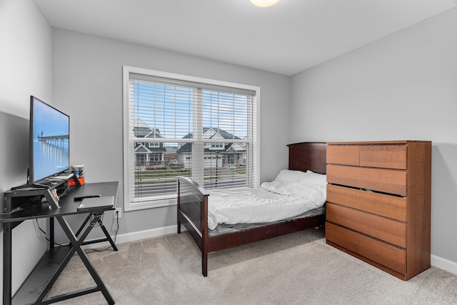 bedroom featuring baseboards and light colored carpet