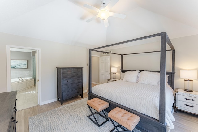 bedroom with a ceiling fan, baseboards, lofted ceiling, light wood-style floors, and connected bathroom