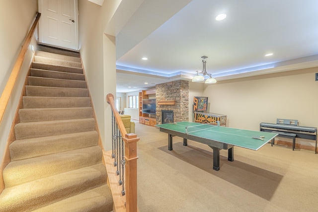 game room featuring recessed lighting, light carpet, a raised ceiling, and a fireplace