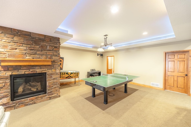 game room featuring visible vents, baseboards, carpet, a tray ceiling, and a fireplace