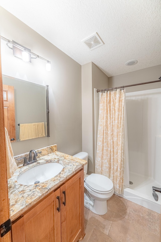 bathroom with visible vents, toilet, a stall shower, and a textured ceiling