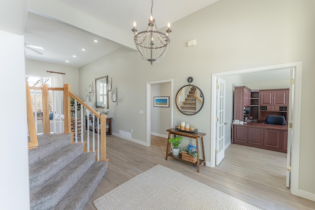 foyer entrance featuring light wood-type flooring, stairs, and baseboards