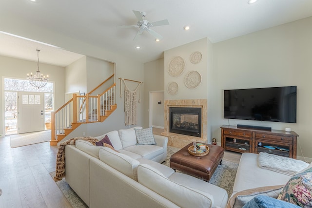 living area with a fireplace, stairway, recessed lighting, and wood finished floors