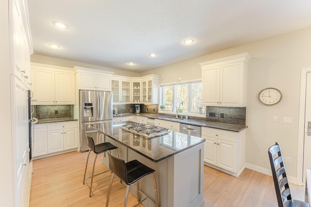 kitchen featuring a breakfast bar area, light wood-style flooring, appliances with stainless steel finishes, and a center island