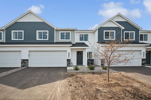 multi unit property featuring a garage, aphalt driveway, board and batten siding, and central AC unit