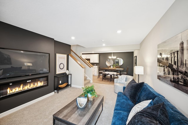 living area featuring recessed lighting, light colored carpet, baseboards, stairs, and a glass covered fireplace