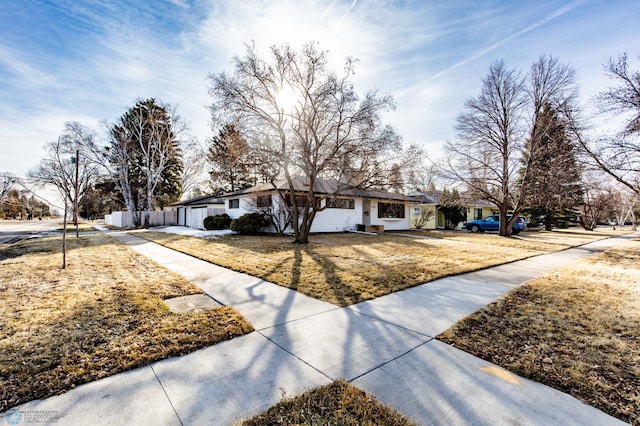 ranch-style home featuring a front lawn and an attached garage