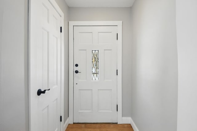 doorway featuring light wood-style flooring and baseboards