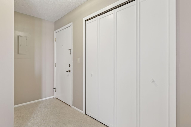 interior space with electric panel, baseboards, and a textured ceiling