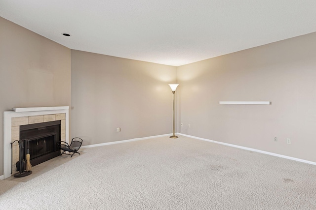 unfurnished living room featuring a fireplace, baseboards, and carpet