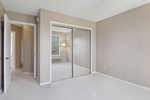 unfurnished bedroom with a closet, baseboards, and carpet flooring