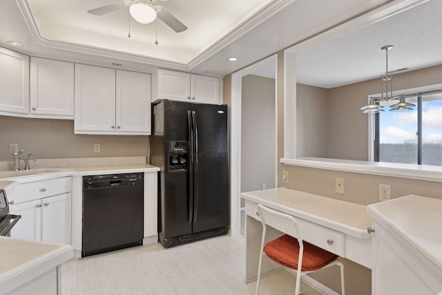 kitchen featuring black appliances, a sink, white cabinetry, light countertops, and built in study area