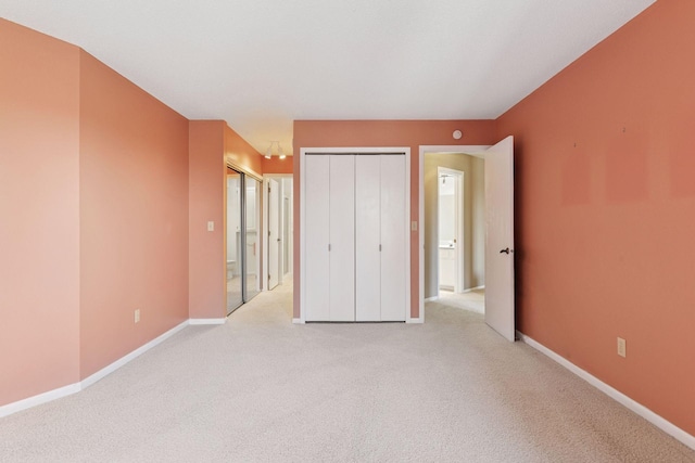 unfurnished bedroom featuring light colored carpet, baseboards, and multiple closets