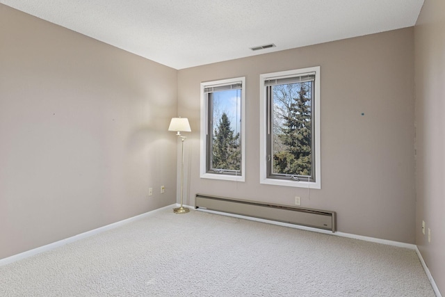 unfurnished room with visible vents, baseboards, carpet, a textured ceiling, and a baseboard radiator