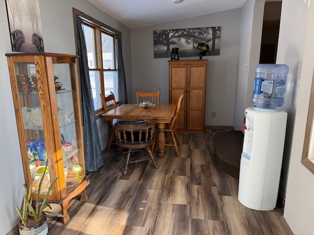 dining space with baseboards and dark wood finished floors