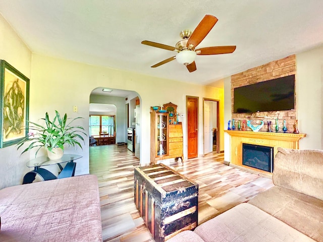 1789 Glynview Trl, Faribault, MN 55021 - living room featuring arched walkways, a ceiling fan, a fireplace, and wood finished floors