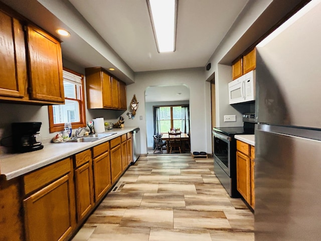 1789 Glynview Trl, Faribault, MN 55021 - kitchen featuring appliances with stainless steel finishes, brown cabinetry, light countertops, a sink, and recessed lighting