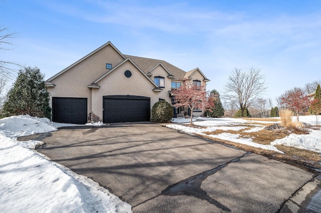 view of front of home featuring stucco siding, driveway, and a garage