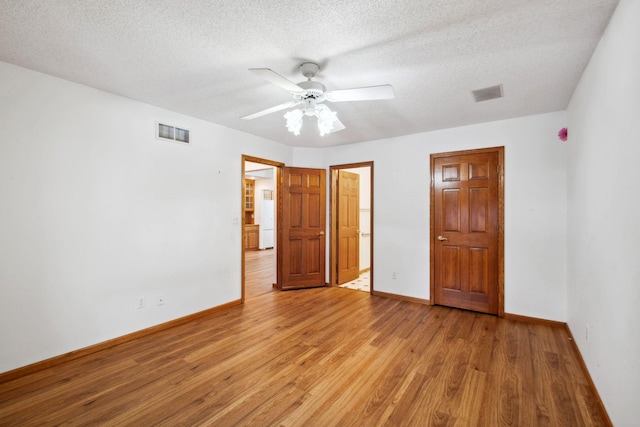 unfurnished bedroom with light wood-type flooring, baseboards, and visible vents