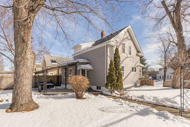 view of front of property featuring a patio, a chimney, and fence