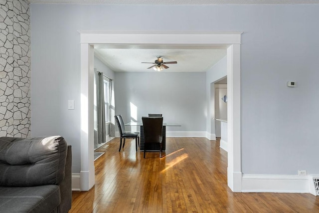 dining room with ceiling fan, baseboards, and hardwood / wood-style flooring