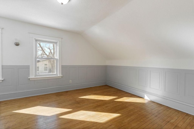 bonus room with lofted ceiling and light wood-style flooring