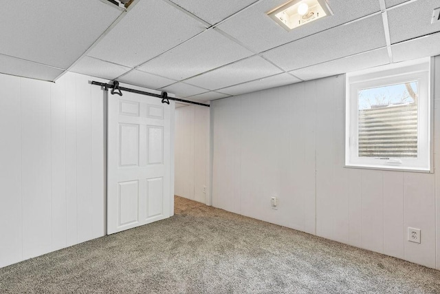 below grade area with carpet floors and a paneled ceiling