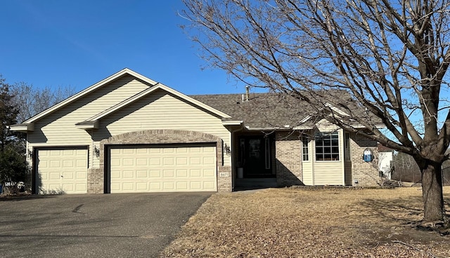 ranch-style house with brick siding, driveway, and a garage