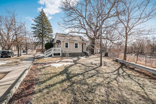 view of side of home featuring fence and brick siding