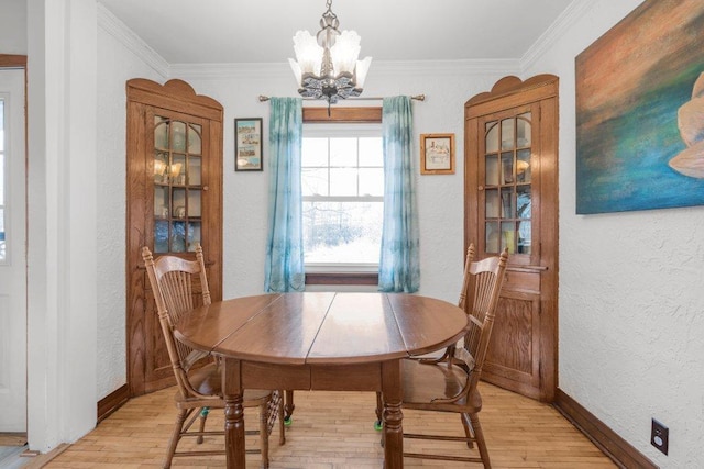 dining room with light wood-style flooring, an inviting chandelier, and ornamental molding