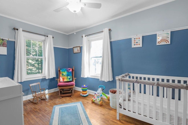 bedroom with a crib, crown molding, and multiple windows