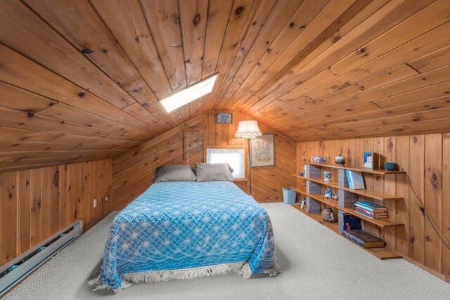 carpeted bedroom featuring a baseboard heating unit, wooden ceiling, wooden walls, and vaulted ceiling with skylight