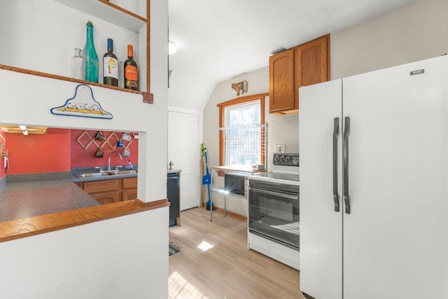 kitchen featuring brown cabinets, a sink, white appliances, light wood-style floors, and lofted ceiling