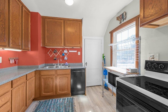 kitchen with light wood-type flooring, black appliances, a sink, brown cabinetry, and light countertops