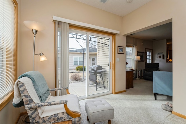 living area featuring visible vents, baseboards, and carpet flooring