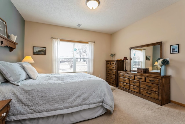 bedroom with visible vents, baseboards, carpet, and a textured ceiling