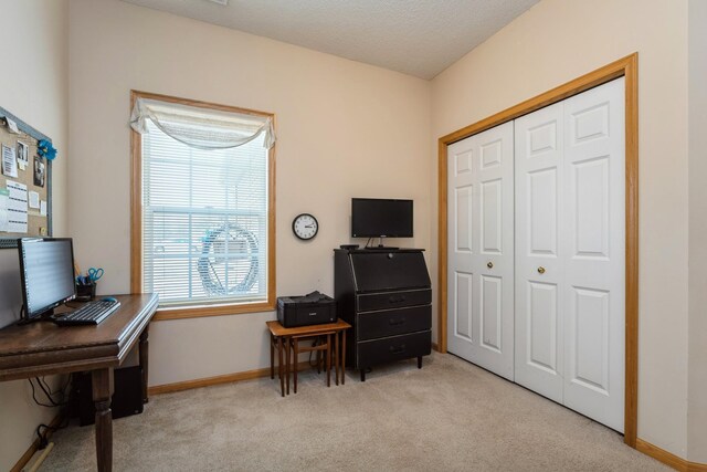 carpeted home office featuring baseboards and a textured ceiling