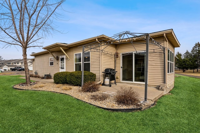 rear view of house with a patio, a yard, and cooling unit