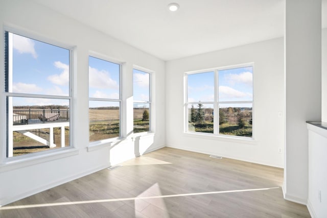 unfurnished sunroom with visible vents and a healthy amount of sunlight