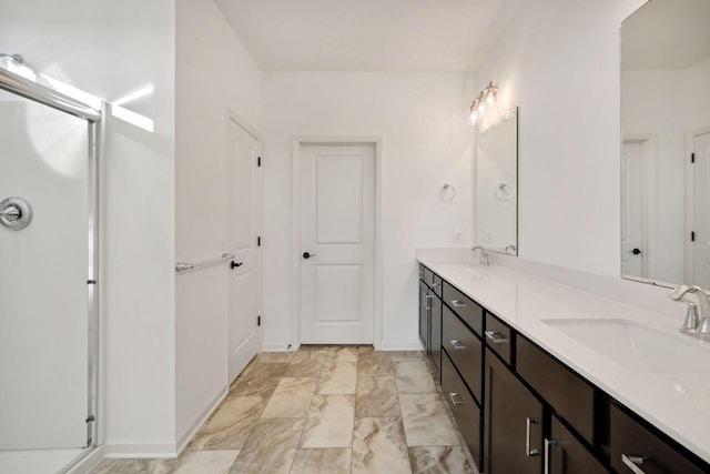 full bathroom with marble finish floor, a sink, a shower stall, and double vanity