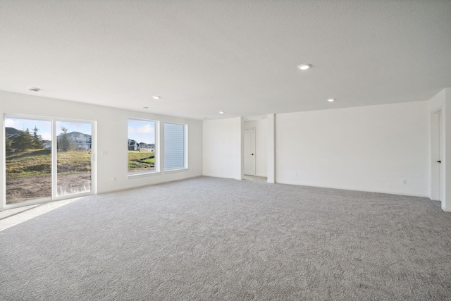 unfurnished living room with light carpet and recessed lighting