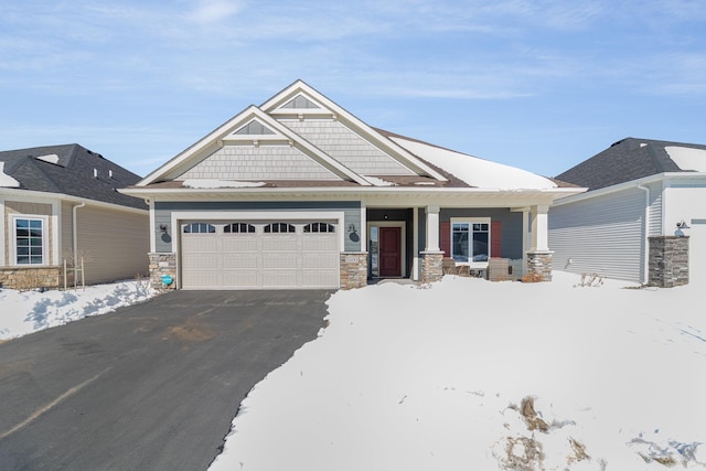 craftsman-style house featuring stone siding, driveway, and an attached garage