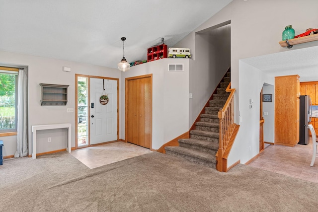 entryway with visible vents, baseboards, stairs, lofted ceiling, and carpet flooring