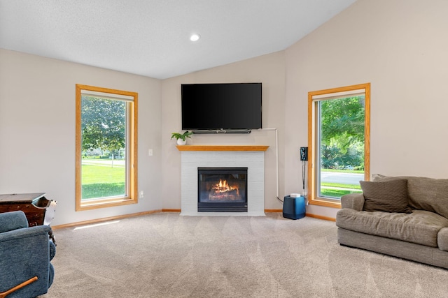 living area featuring carpet, baseboards, lofted ceiling, a fireplace with flush hearth, and recessed lighting