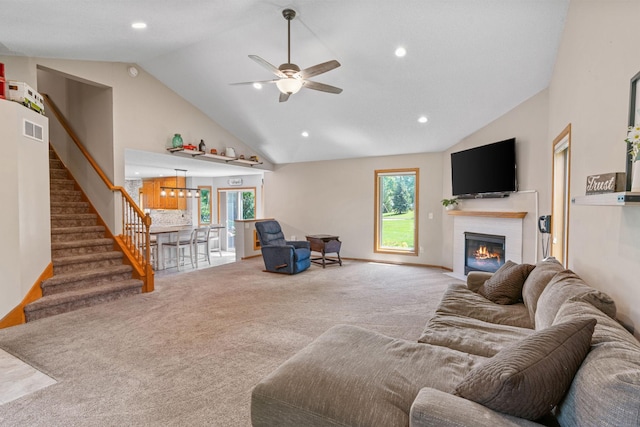 carpeted living room featuring stairway, high vaulted ceiling, a fireplace with flush hearth, recessed lighting, and ceiling fan