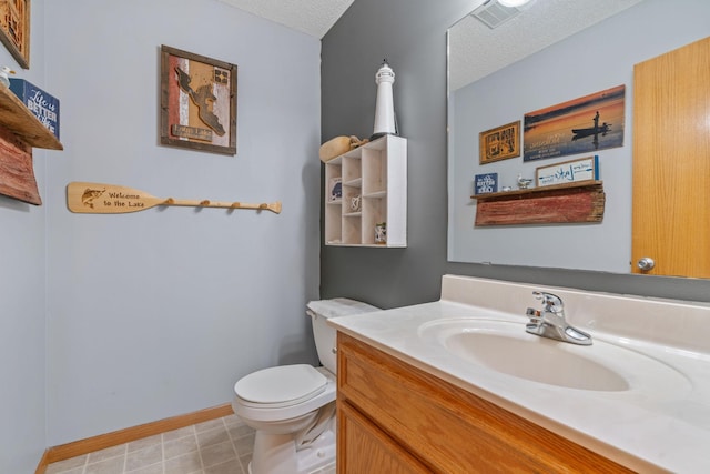 bathroom with vanity, visible vents, baseboards, a textured ceiling, and toilet