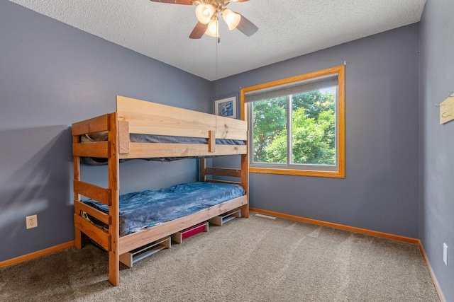 bedroom featuring baseboards, carpet, a ceiling fan, and a textured ceiling