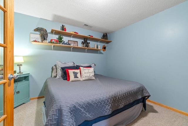 bedroom featuring visible vents, baseboards, and a textured ceiling