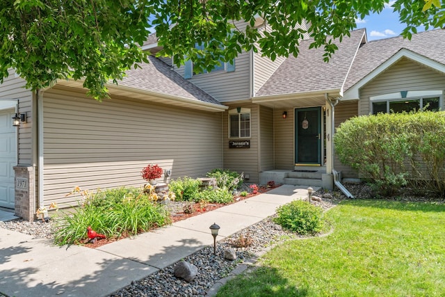 cape cod-style house with a front yard, an attached garage, and a shingled roof